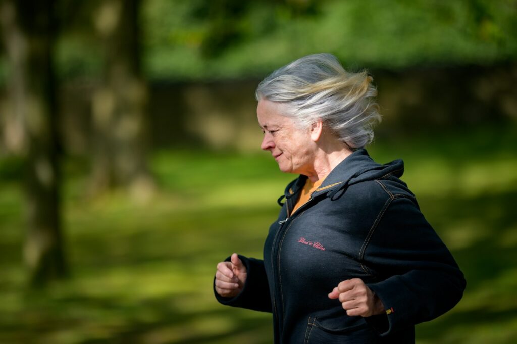 Frau joggt im Park – Ausdauer als Baustein beim Abnehmen in den Wechseljahren