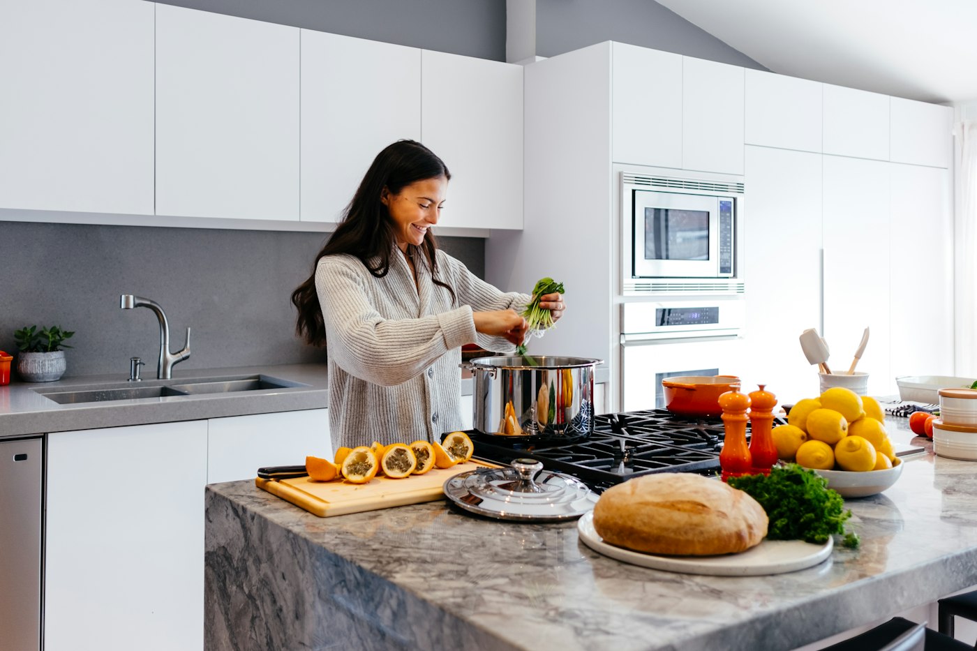 Lächelnde Frau kocht zuhause frisch – Abnehmen ohne Sport beginnt in der Küche