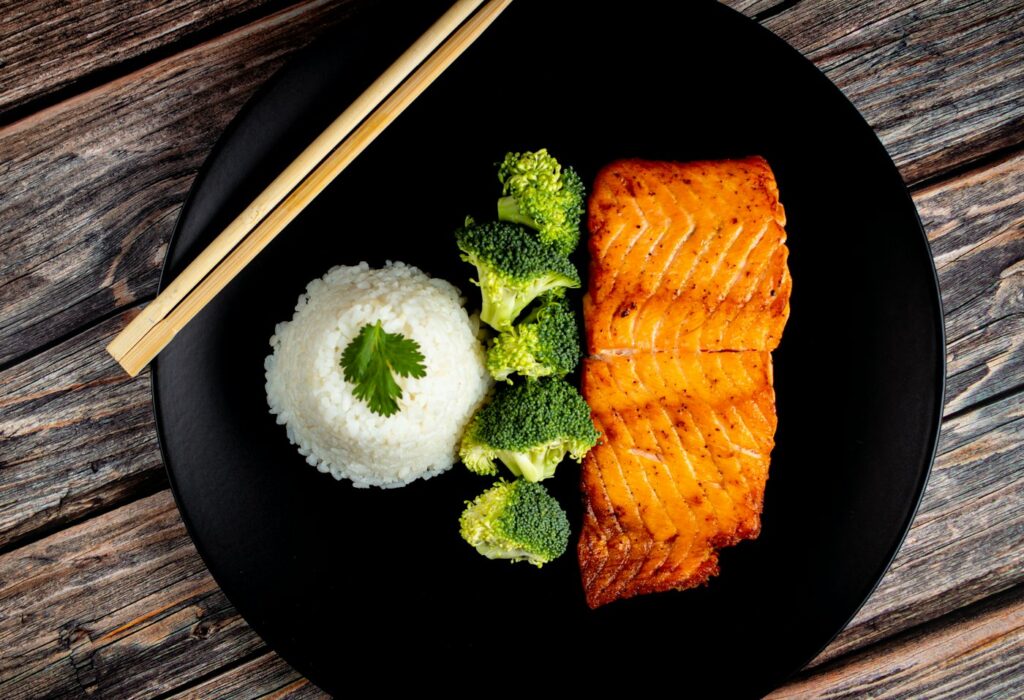 Lachs mit Brokkoli auf schwarzem Teller als Rezept für antientzündliche Ernährung