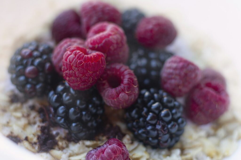 Haferflocken-Bowl mit Himbeeren und Heidelbeeren als ballaststoffreiche Lebensmittel zum Frühstück
