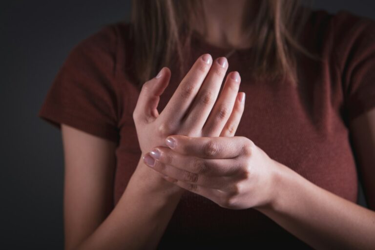 Hände schlafen nachts ein: Frau hält ihre schmerzende, kribbelnde Hand
