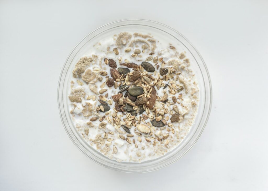Schale mit Haferflocken und Milch als Frühstück, Haferflocken gesund genießen