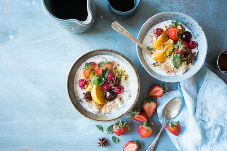 Zwei Schalen Porridge mit Obst zeigen, wie Haferflocken gesund schmecken