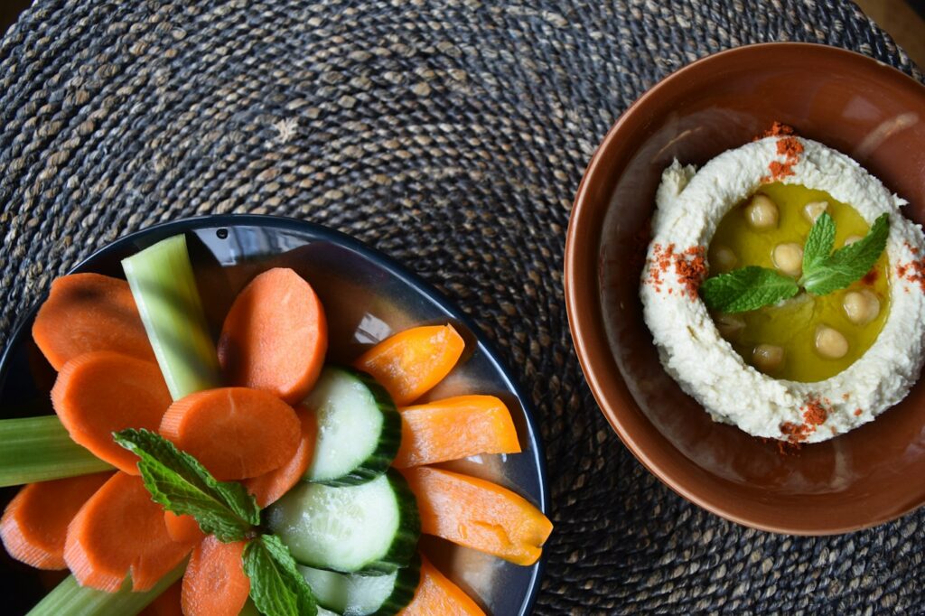 Karotten und Staudensellerie mit Hummus als Snack, um Heißhunger stoppen zu können