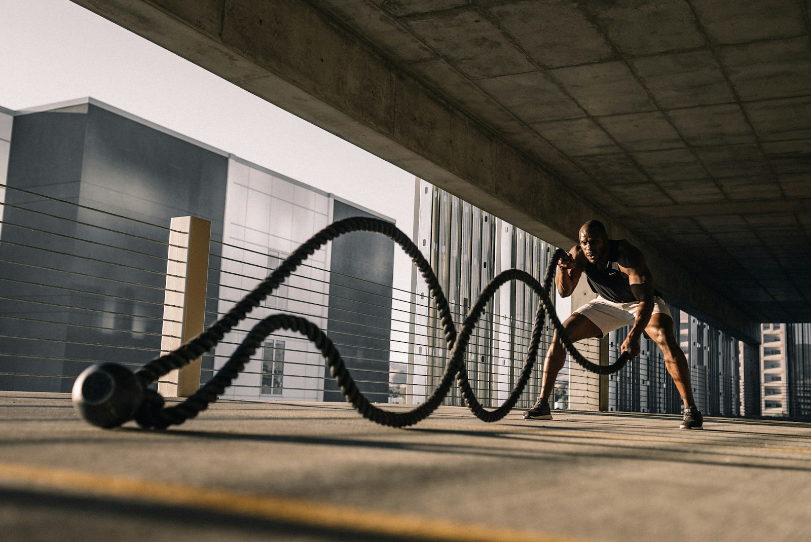 HIIT Training: Mann trainiert draußen intensiv mit schweren Battle Ropes