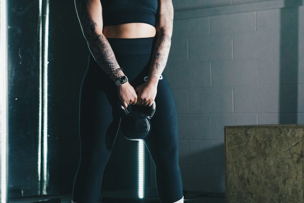 Frau hält eine Kugelhantel im Fitnessstudio beim Kettlebell Training