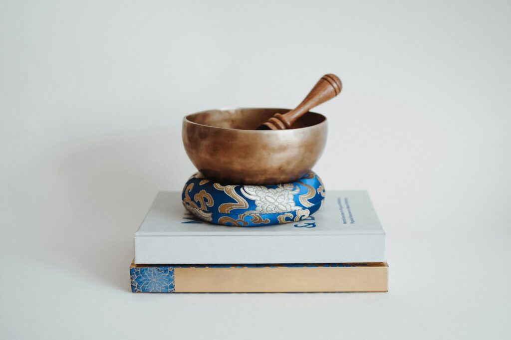 Klangschale und Klöppel liegen auf Büchern – Einstieg in die Klangschalen Meditation
