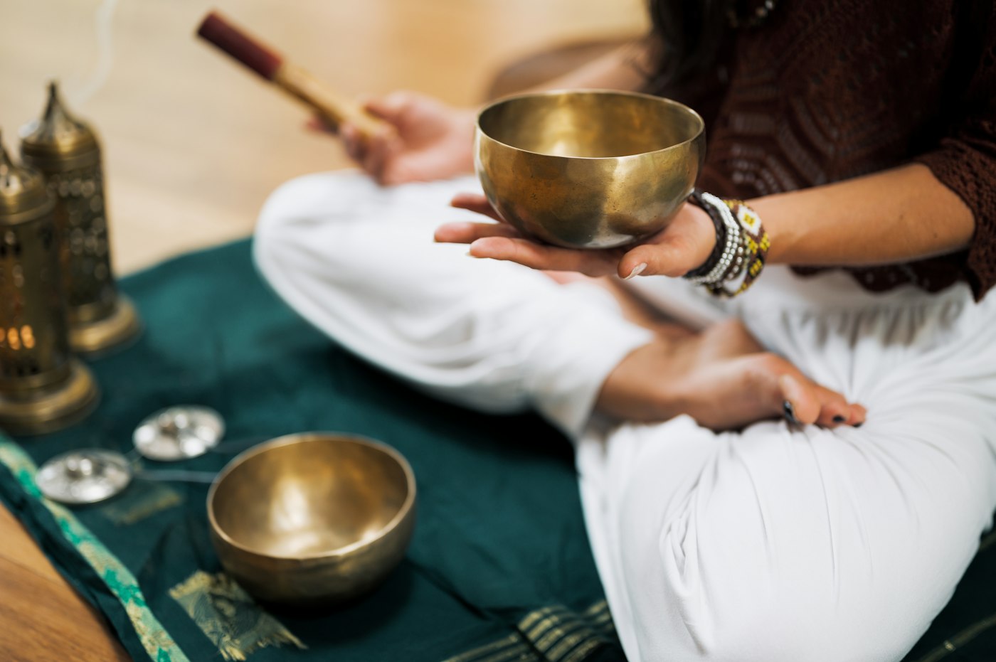 Person hält eine Messing-Klangschale auf grünem Tuch zur Klangschalen Meditation