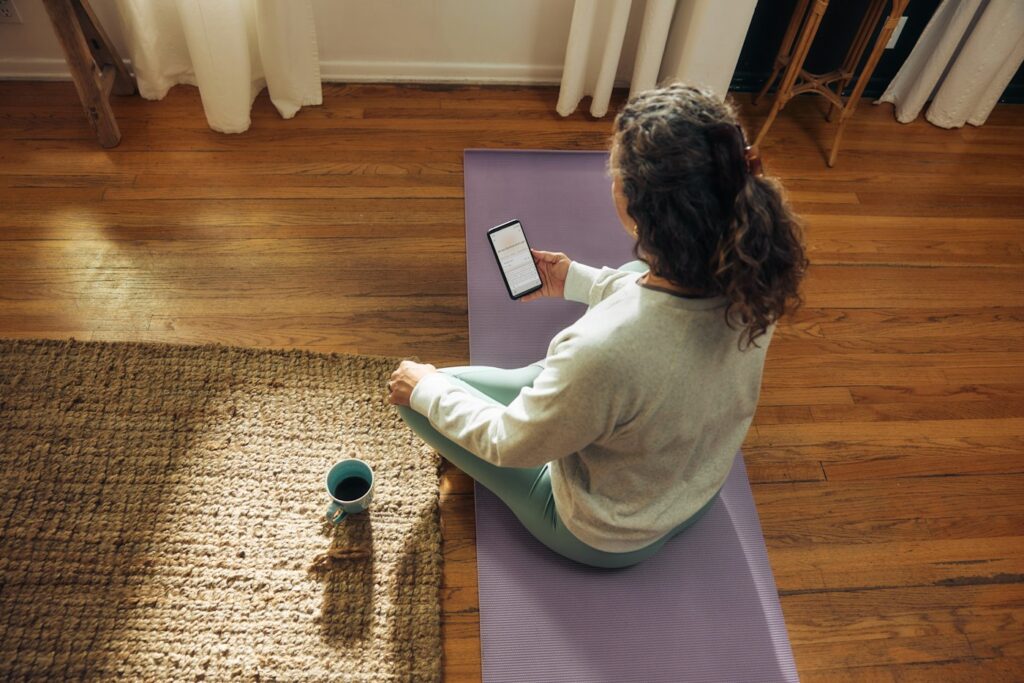 Frau übt zuhause auf der Yogamatte Meditation für Anfänger mit Timer