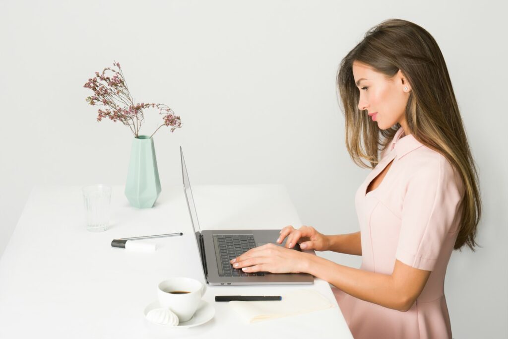 Frau arbeitet am Laptop, Bildschirmarbeit erschwert es, die Nacken Verspannung lösen zu können