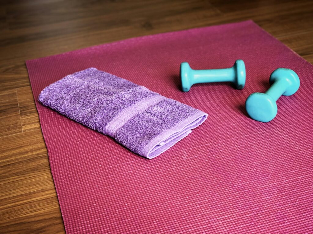 Matte, Hanteln und Handtuch bereit für Pilates Übungen zuhause