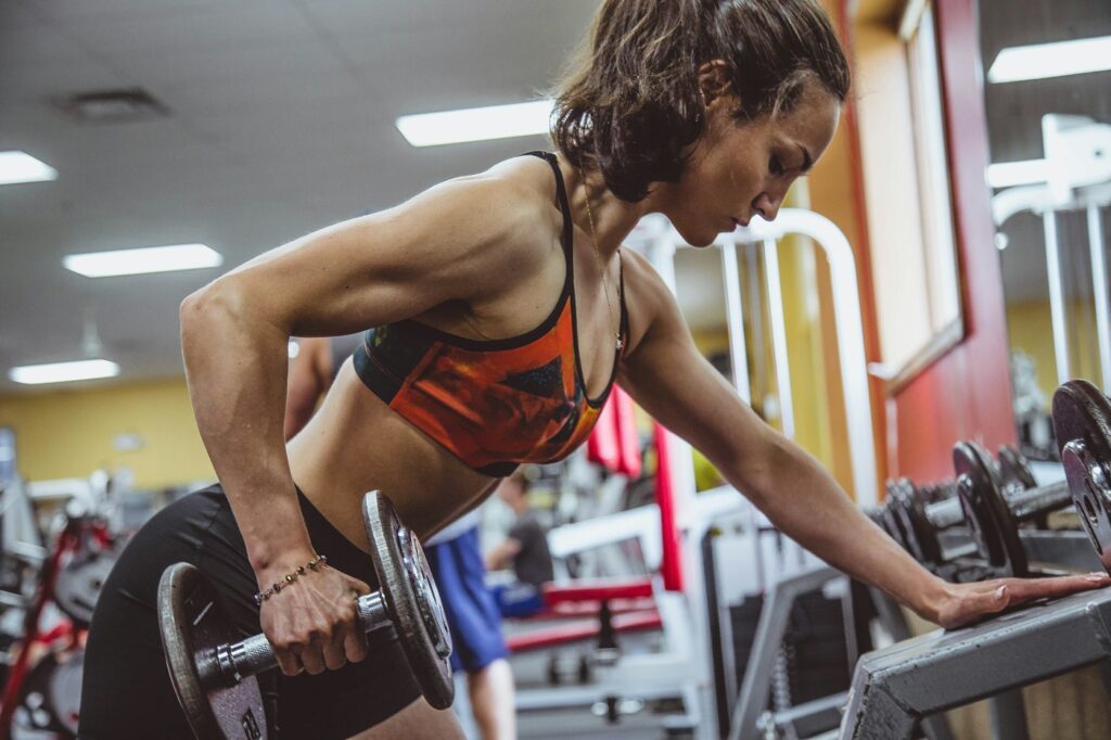 Konzentrierte Frau bei Po Übungen an einem Gerät im Fitnessstudio