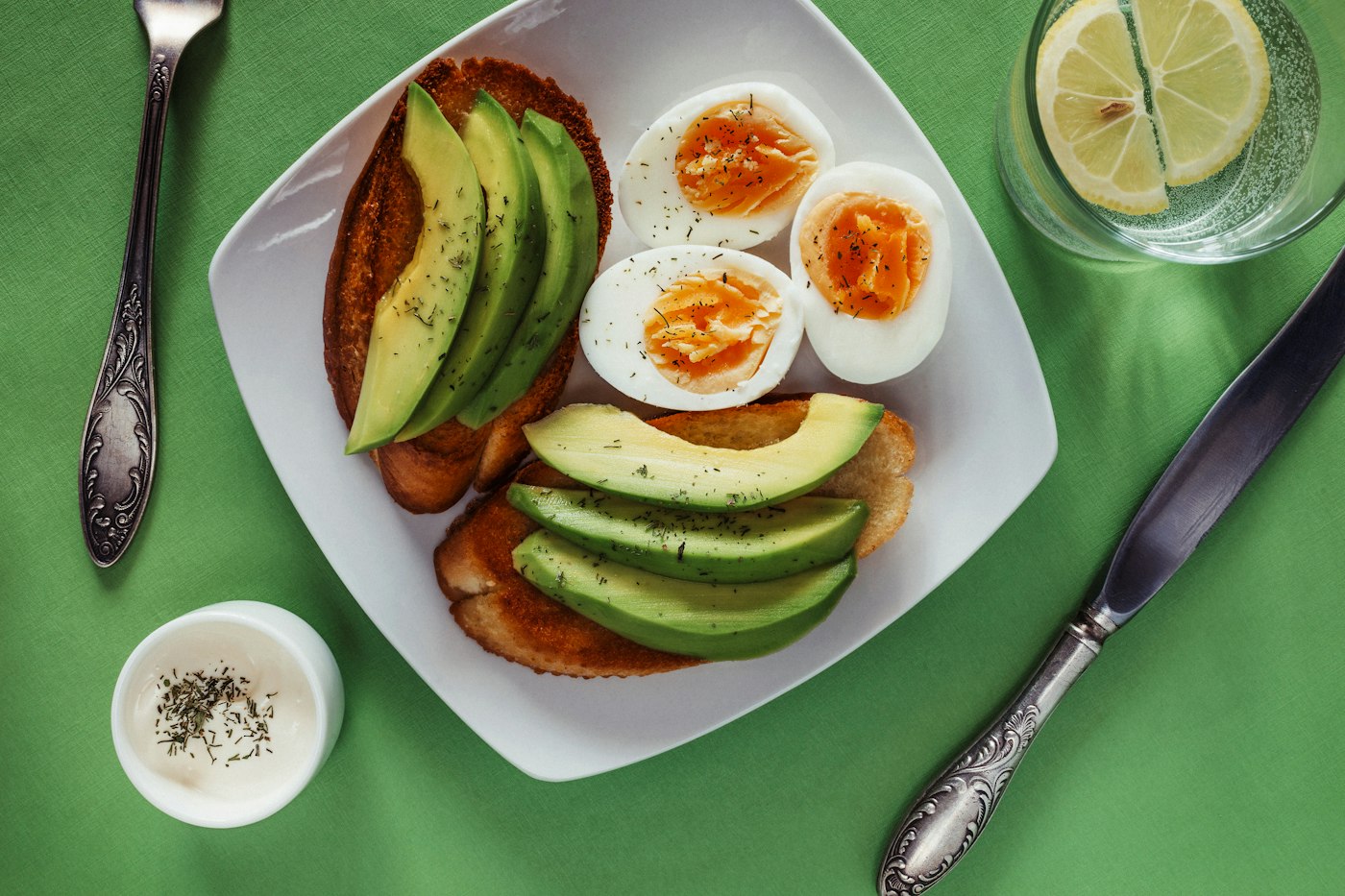 Teller mit Eiern und Avocado als proteinreiche Lebensmittel zum Frühstück