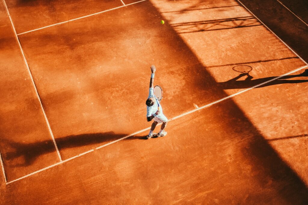 Tennisspieler beim Schlag, typischer Auslöser für Schmerzen im Ellenbogen außen
