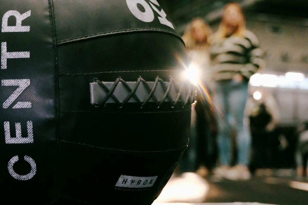 Medizinball vor Trainierenden – Was ist Hyrox an der Station Wall Balls