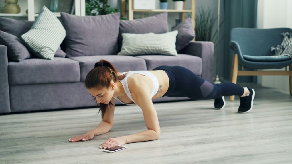 Frau macht Liegestütze auf dem Boden beim Workout zuhause ohne Geräte
