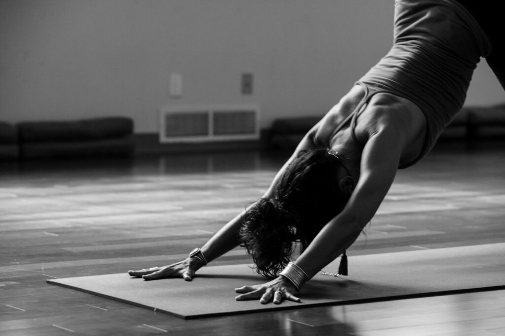 Frau in sanfter Vorbeuge auf dem Boden während einer Yin Yoga Einheit