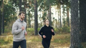 Paar beim ruhigen Zone 2 Laufen auf einem Waldweg